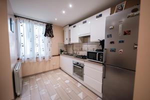 eine Küche mit weißen Schränken und einem Kühlschrank in der Unterkunft La Sérénité Urbaine in Bischheim
