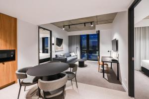 uma sala de estar com mesa e cadeiras em Nesuto Docklands em Melbourne