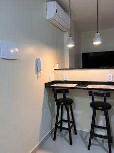 uma cozinha com dois bancos de bar e um telefone em Loft 215 da Lapa, Rio de Janeiro no Rio de Janeiro