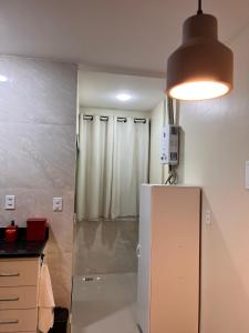 uma cozinha com um frigorífico branco e uma luz em Loft 215 da Lapa, Rio de Janeiro no Rio de Janeiro