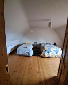 an attic bedroom with two beds and a wooden floor at Justosleep in Kilkenny