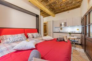 1 cama roja en una habitación con cocina en Dream House en Cuneo