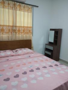 a bed with a pink bedspread with hearts on it at Apartamento nueva era in David