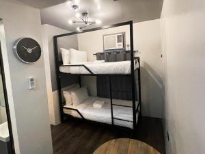 a room with two bunk beds and a clock on a wall at mySTAY Hotel BGC North in Manila