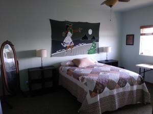 1 dormitorio con 1 cama con una foto de Navidad en la pared en Ocean View Paradise! en Hawaiian Ocean View