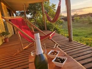- une bouteille de vin et une chaise sur une terrasse couverte dans l'établissement Maori Tea Rapa Nui stunning Maori villa Easter Island with ocean view, à Hanga Roa