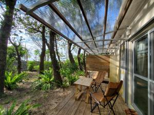 a patio with a table and chairs on a deck at Kuganipi Beachside Inn Iriomote in Iriomote