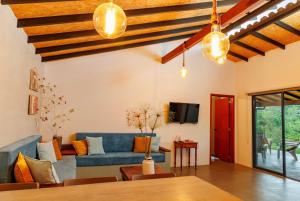 uma sala de estar com um sofá azul e uma televisão em Cabaña Capella em Pinchote
