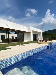 a house with a swimming pool in front of a house at Casa icaro in Tocaima