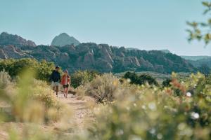 two people walking on a trail in the mountains at AutoCamp Zion in Virgin