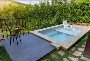 a small swimming pool with a chair and a table at Cabaña Capella in Pinchote