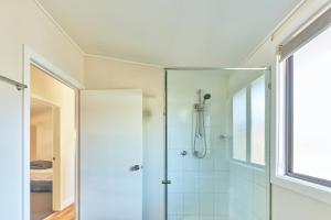 uma casa de banho com um chuveiro e uma porta de vidro em NRMA Sydney Lakeside Holiday Park em Narrabeen