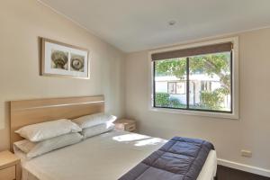 Schlafzimmer mit einem Bett und einem Fenster in der Unterkunft NRMA Sydney Lakeside Holiday Park in Narrabeen