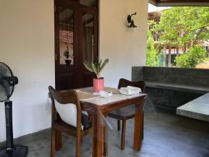 een houten tafel en stoelen in een kamer bij LOHAS Villa Hiriketiya in Dikwella