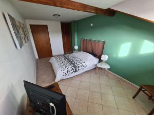 a bedroom with a bed and a flat screen tv at Gîte cosy au bord de la Moselle, proche Nancy, activités plein air, tout inclus, parking gratuit. - FR-1-584-175 in Fontenoy-sur-Moselle