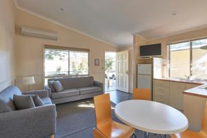 Una cocina y una sala de estar con una mesa y un sofá. en Big4 Sydney Lakeside Holiday Park, en Narrabeen