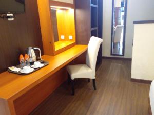 escritorio con silla y espejo en la habitación en Segara Anak Hotel, en Kuta Lombok