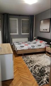 a bedroom with a bed and a rug at Boris Apartmani Kraljevo in Kraljevo