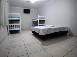 une chambre avec un lit et deux étagères blanches dans l'établissement Chácara Oliveira, à Socorro 60 autres photos