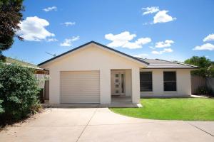 une maison blanche avec un garage dans l'établissement Lovely 3 Bed, 2 Bath in the City Centre!, à Wagga Wagga