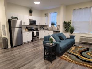 a living room with a blue couch and a kitchen at Insta worthy 2 Bd/2 Ba in Bound Brook in Bound Brook
