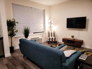a living room with a blue couch and a television at Insta worthy 2 Bd/2 Ba in Bound Brook in Bound Brook