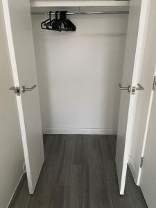 an empty room with two white doors and a wooden floor at Modern 1-Bedroom Apartment close to City Airport in London