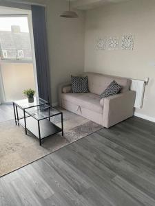 a living room with a couch and a coffee table at Modern 1-Bedroom Apartment close to City Airport in London