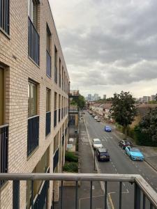 vistas a una calle de la ciudad con coches aparcados en la carretera en Modern 1-Bedroom Apartment close to City Airport en Londres