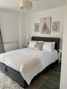 sypialnia z dużym łóżkiem z białą pościelą i poduszkami w obiekcie Modern 1-Bedroom Apartment close to City Airport w Londynie