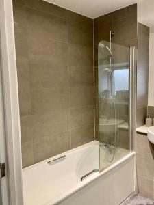 een douche met een glazen deur in de badkamer bij Modern 1-Bedroom Apartment close to City Airport in Londen