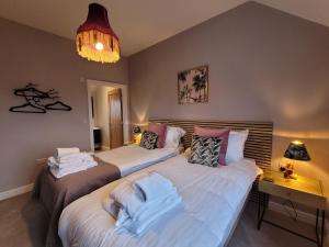1 dormitorio con 2 camas, escritorio y lámpara de araña en Eastgate Barn, Ashlin Farm Barns en Lincoln