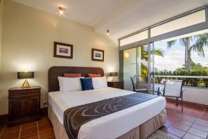 a bedroom with a large bed and a large window at Club Tropical Resort - Official Onsite Reception & Check In in Port Douglas +208 photos