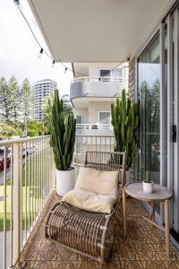 a porch with a chair and a table on a balcony at Chic beachside getaway 2BR 2Bath Fully Equipped in Gold Coast