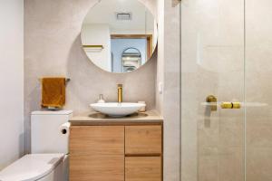 ein Bad mit einem Waschbecken und einem Spiegel in der Unterkunft Chic beachside getaway 2BR 2Bath Fully Equipped in Gold Coast