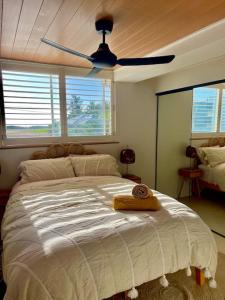 a bedroom with a large bed with a ceiling fan at Chic beachside getaway 2BR 2Bath Fully Equipped in Gold Coast