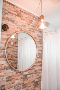 ein runder Spiegel, der an einer Ziegelwand hängt in der Unterkunft Casa Patagonia #991 in Coihaique