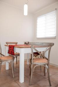 une table à manger avec deux chaises, une table et une fenêtre dans l'établissement Casa Patagonia #991, à Coyhaique