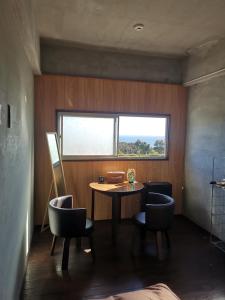 a room with a table and chairs and a window at Umi no Mieru Ie Ocean View in Nishinoomote