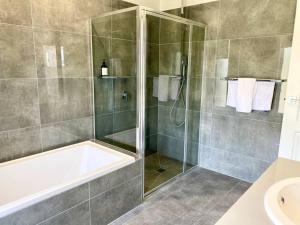 ein Bad mit einer Dusche, einer Badewanne und einem Waschbecken in der Unterkunft Wagga Apartments #2! in Wagga Wagga + 2 Fotos