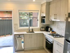 eine Küche mit Spüle und Herd oberen Backofen in der Unterkunft Wagga Apartments #2! in Wagga Wagga