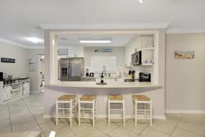 uma cozinha com um lavatório e um balcão com bancos de bar em Home Wpool By Pmi Unit Dfs em Deerfield Beach