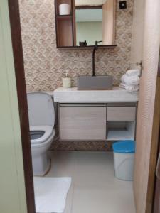 a bathroom with a toilet and a sink and a mirror at Chácara aconchego do Valle in Petrolina