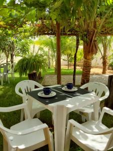 Chácara aconchego do Valle في بترولينا: طاولة بيضاء وكراسي في ساحة
