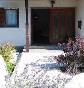 een voordeur van een huis met paarse bloemen bij Ferienwohnung Greimelberg in Frasdorf +4 foto's