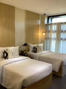 Cette chambre comprend 2 lits et une fenêtre. dans l'établissement D' Residences, à Cebu