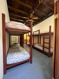 Habitación con 3 literas en una habitación en Hostel Tuanis Surf Camp, en Santa Teresa Beach