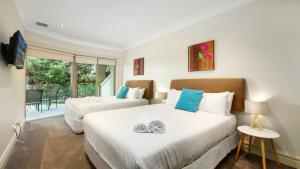 a bedroom with two beds and a balcony at Unit 18 - 3 Bed Part Ocean View in Terrigal