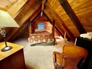 a attic room with a bed and a desk and a chair at Good Life Cabin 1 in Bryson City