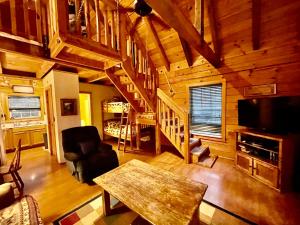 ein Wohnzimmer mit einem Tisch und einer Treppe in einer Hütte in der Unterkunft Good Life Cabin 1 in Bryson City